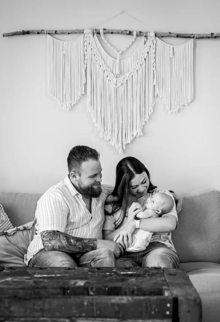Eltern mit Baby auf dem Sofa bei einem natürlichen Familienshooting zuhause