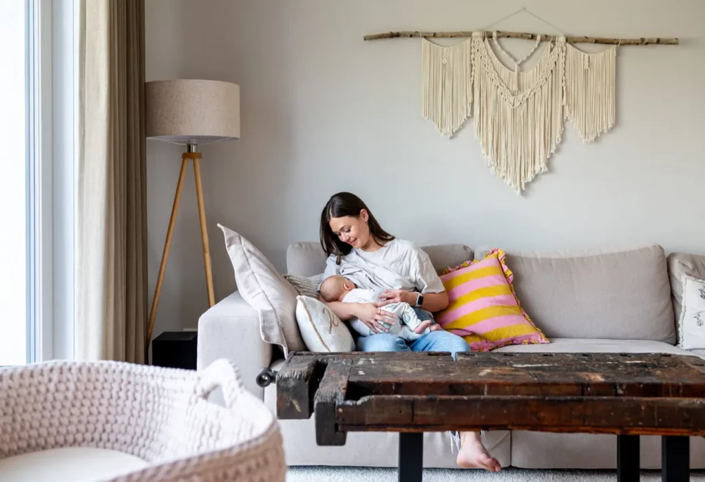 Mutter sitzt mit ihrem Baby auf dem Sofa bei einem entspannten Familienshooting
