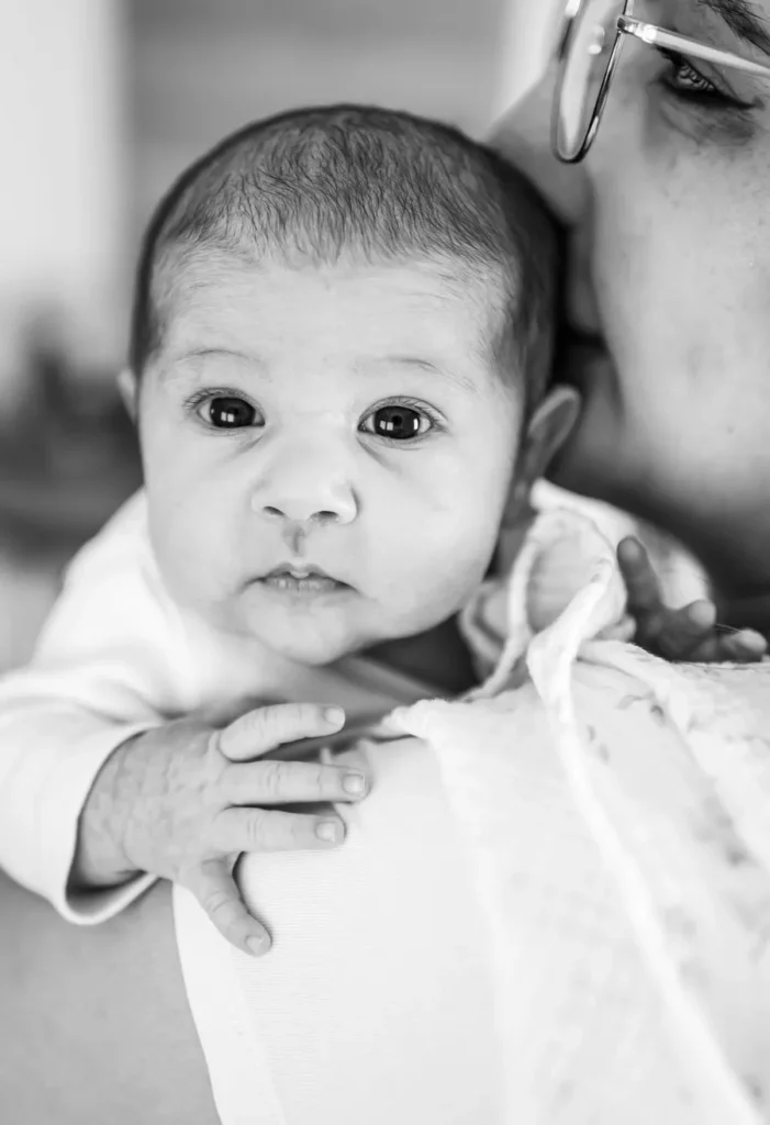 Liebevoller Moment zwischen Mutter und Baby bei einem natürlichen Fotoshooting zuhause