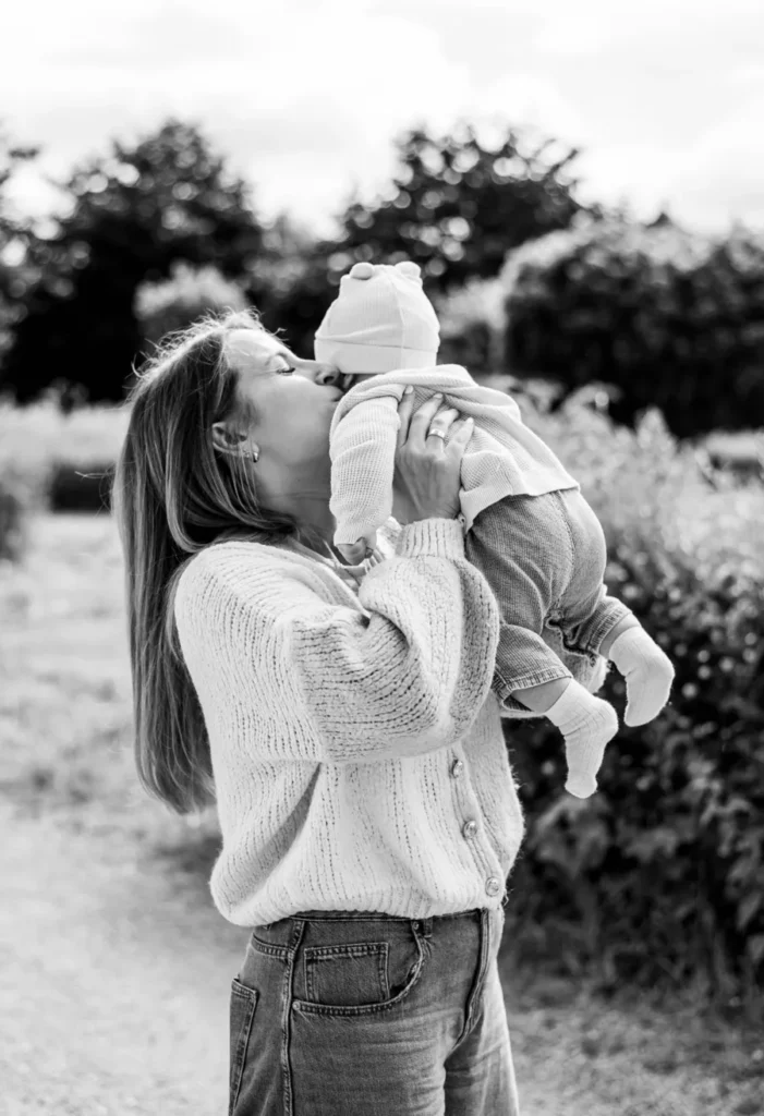 Natürlicher Moment zwischen Mutter und Baby bei einem liebevollen Outdoor-Fotoshooting