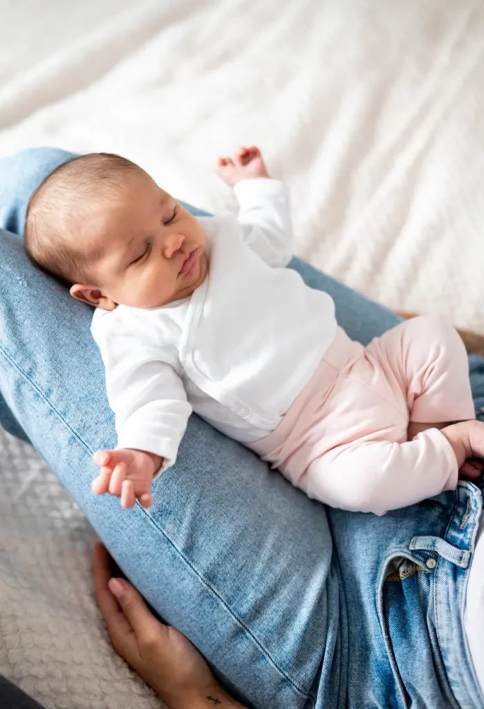 Entspanntes Baby liegt auf dem Schoß eines Elternteils