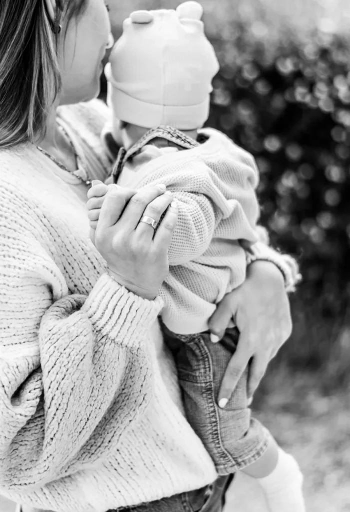 Natürlicher Moment zwischen Mutter und Baby bei einem liebevollen Outdoor-Fotoshooting