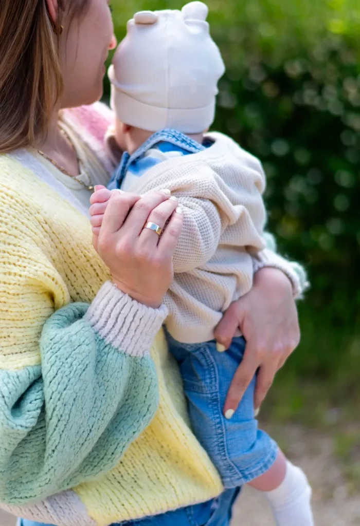 Detail von pastellfarbenem Strickpullover und heller Babykleidung