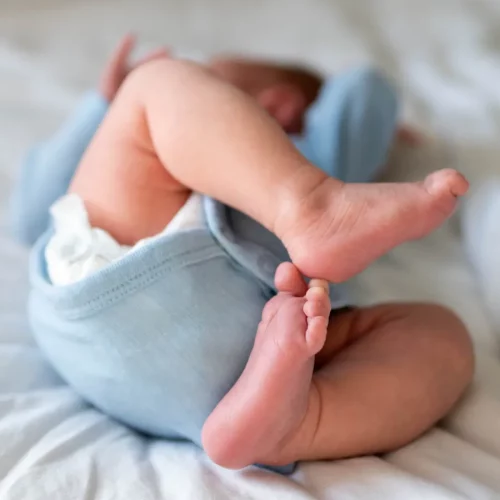 Detailaufnahme der kleinen Füße eines Neugeborenen bei einem entspannten Babyshooting zuhause